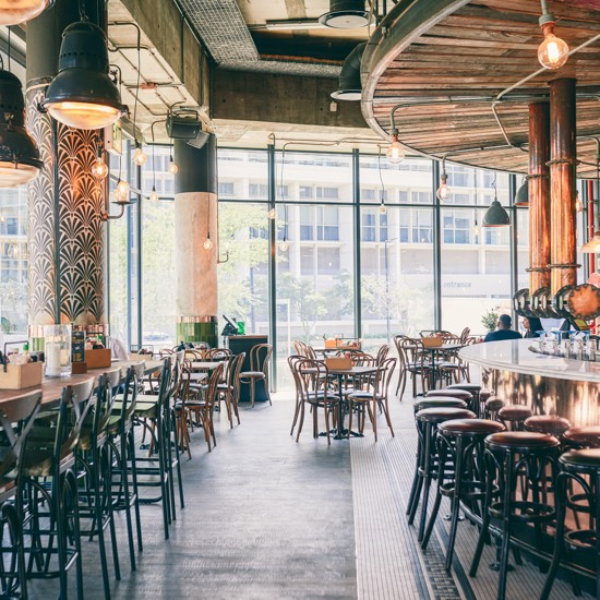 Indoor view of a bar area of a restaurant with copper decorations and barstools